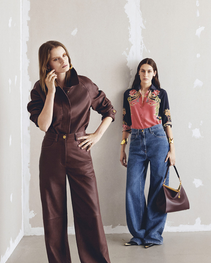 two women, one wearing a leather shirt and one wearing floral printed silk shirts