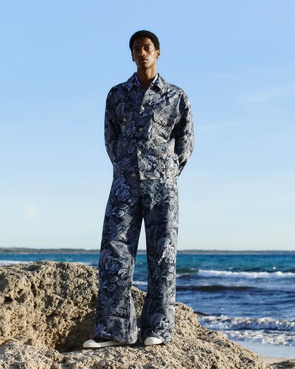 Man on a cliff wearing a denim jacket and trousers - link to MAN's ETRO summer collection