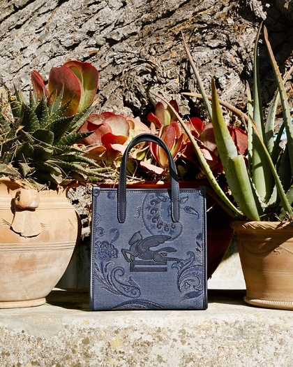 Blue Love Trotter bag with plants in the background - link to woman's bags