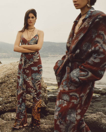 Woman on a beach wearing a floral asymmetric dress