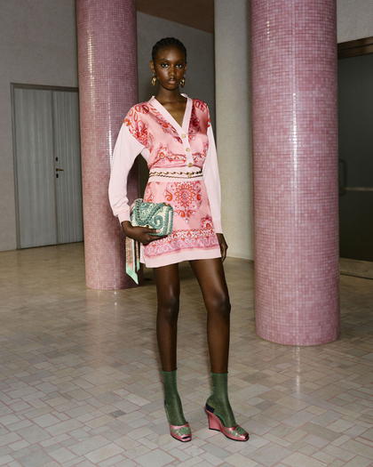 The model wears a pink paisley Etro mini dress paired with green socks, pink wedges, and a textured green clutch.