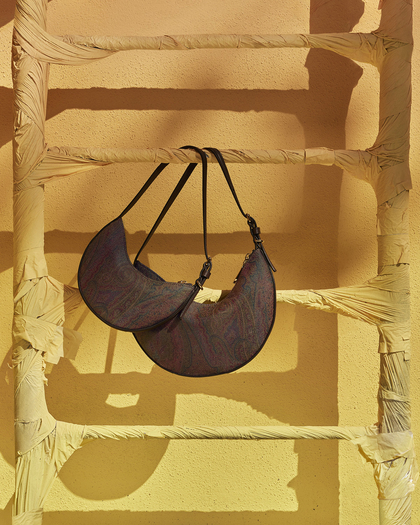 Hobo bags in two different dimension hanged on a yellow stair