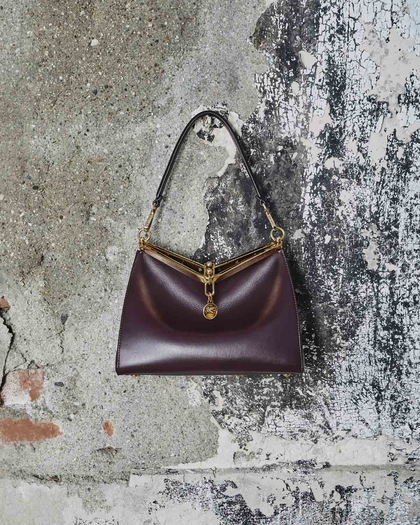 bordeaux medium vela bag in front of a wall