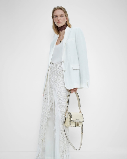 woman in white TAILORED PAISLEY JACQUARD JACKET, crocheted knit trousers and white crown me bag - SS23 woman collection