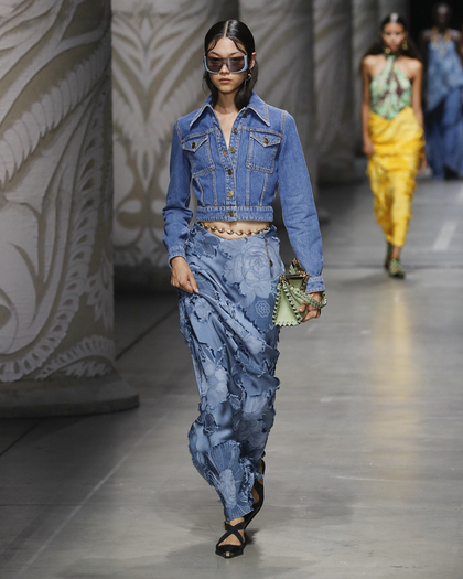 Woman wearing a SILK JACQUARD SKIRT and a DENIM JACKET of runway collection ss24