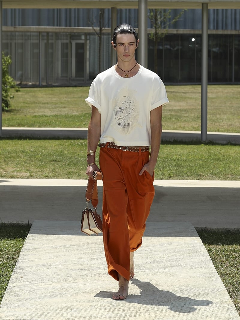 Etro Man Fashion Show SS23; Orange Palazzo Trousers With Patch and T-Shirt With Floral Embroidery