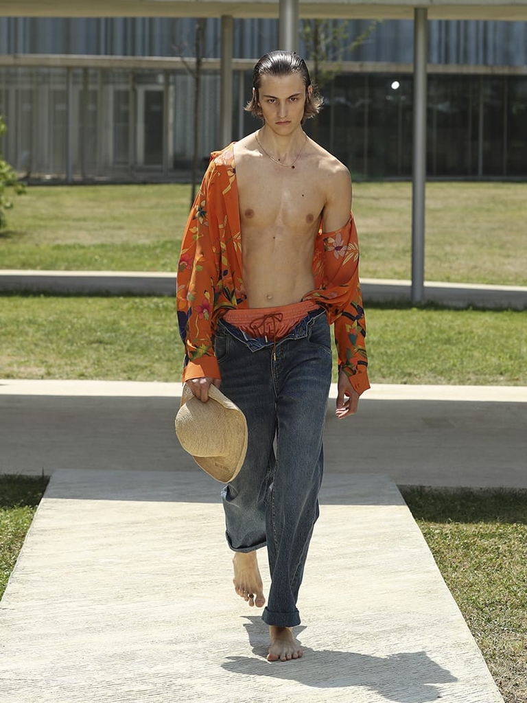 Etro Man Fashion Show SS23; Denim Jeans With Mini Studs, Leafy Floral Silk Orange Shirt and in the hand Raffia Hat
