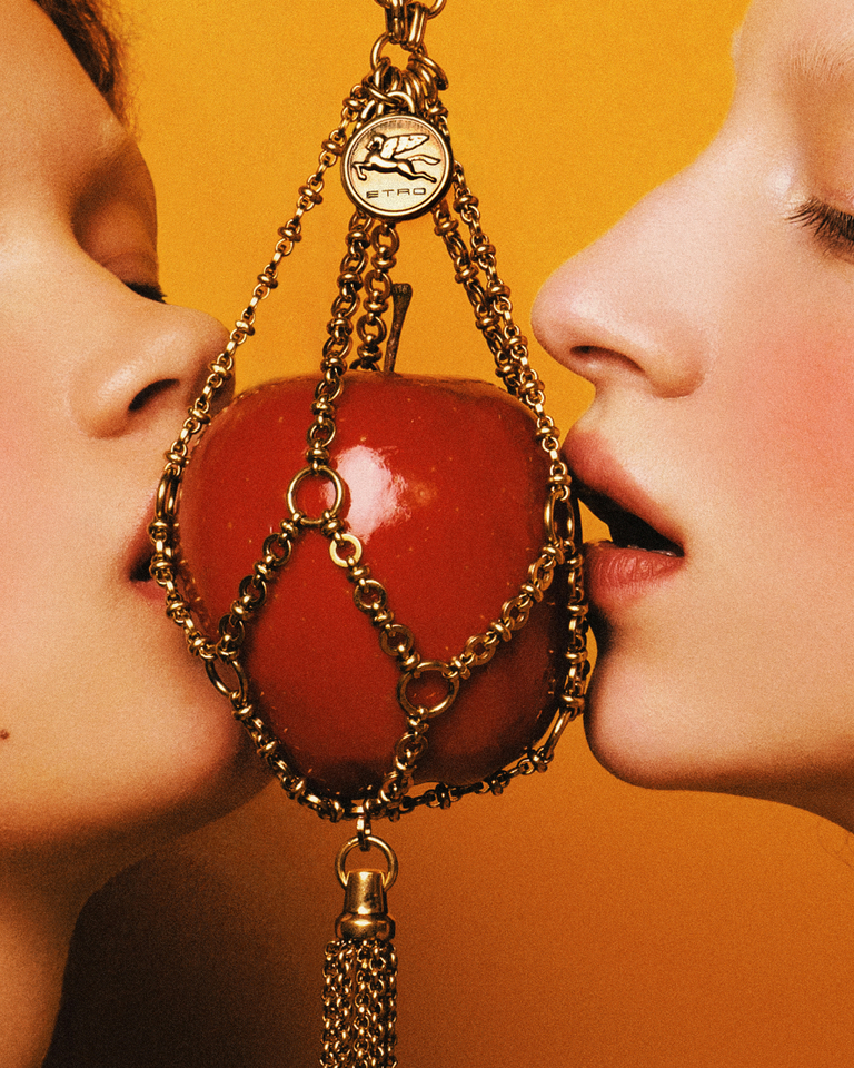 Two women kissing the apple chain holder - SS23 Etro ADV campaign by Marco De Vincenzo