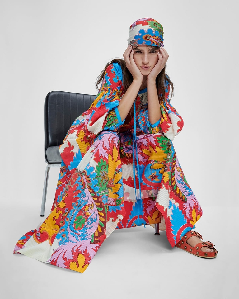 Woman sitting on a chair wearing tunic dress with archive paisley print - SS23 woman collection