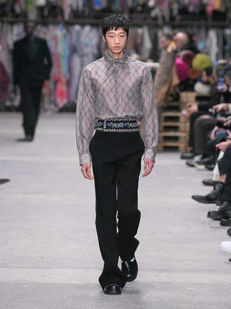 Model with grey shirt with geometric patterns, grey scarf and black trousers Etro fashion show fall winter collection 2023/2024