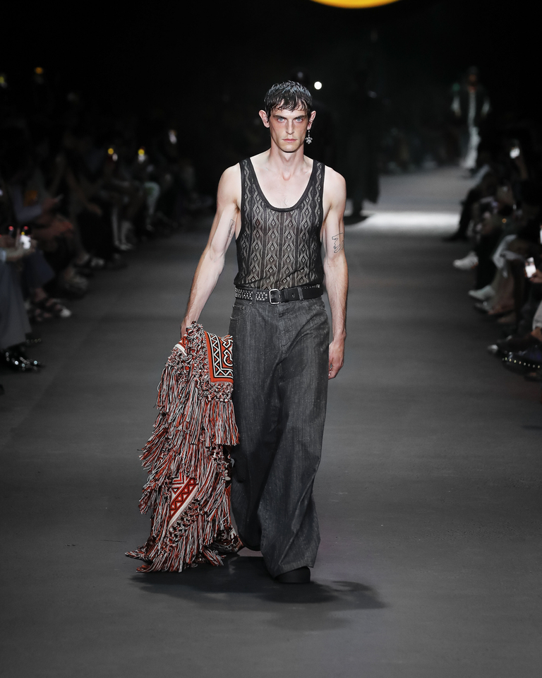 Model with baggy trousers and black low-cut tank top on the Etro 2024 men's fashion show