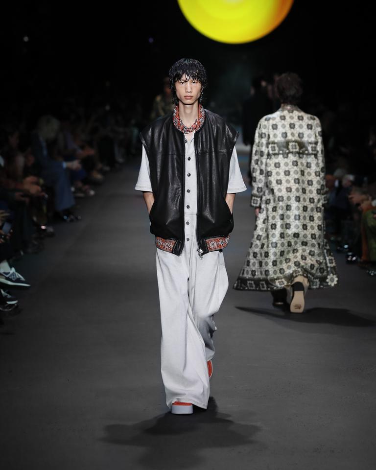 Model with black leather sleeveless jacket, scarf and loose white trousers Etro Spring Summer collection 2024 fashion show