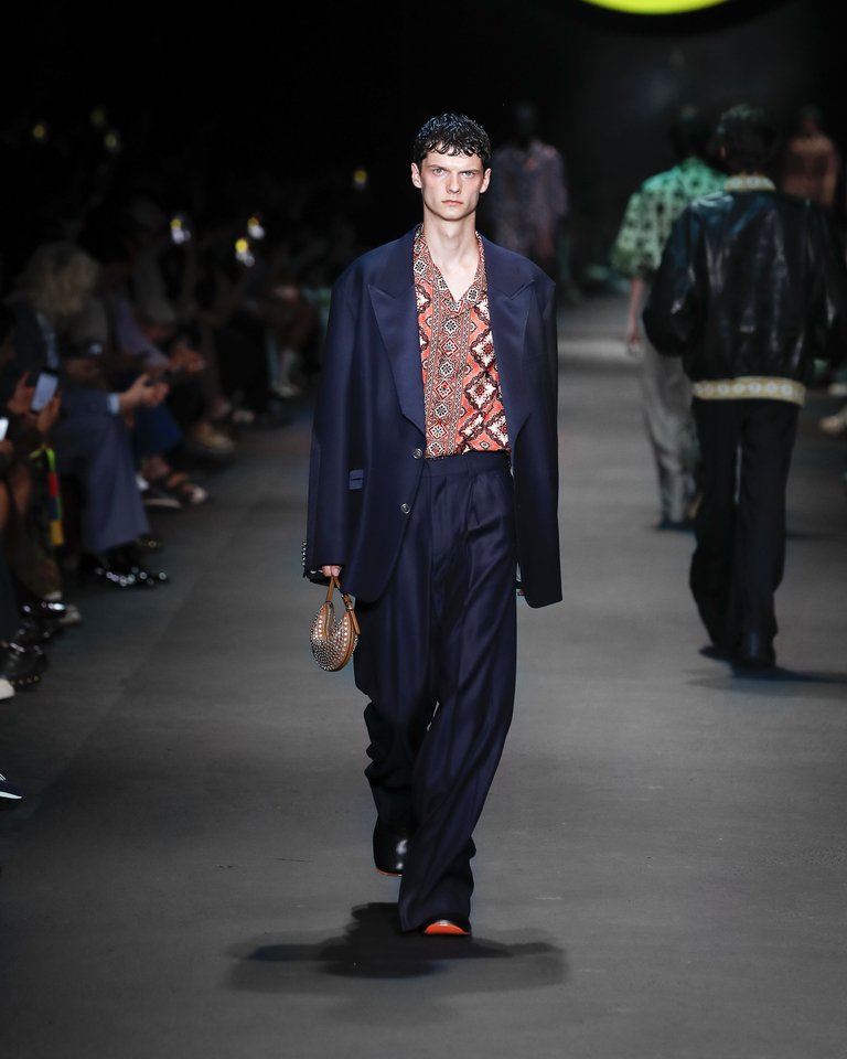Model with blue elegant suit, shirt with floral patterns and handbag Etro Spring Summer collection 2024 fashion show