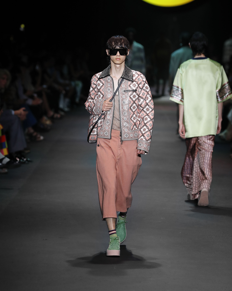 Model with sunglasses, denim jacket with geometric patterns, transparent tank top and orange trousers Etro Spring Summer collection 2024 fashion show