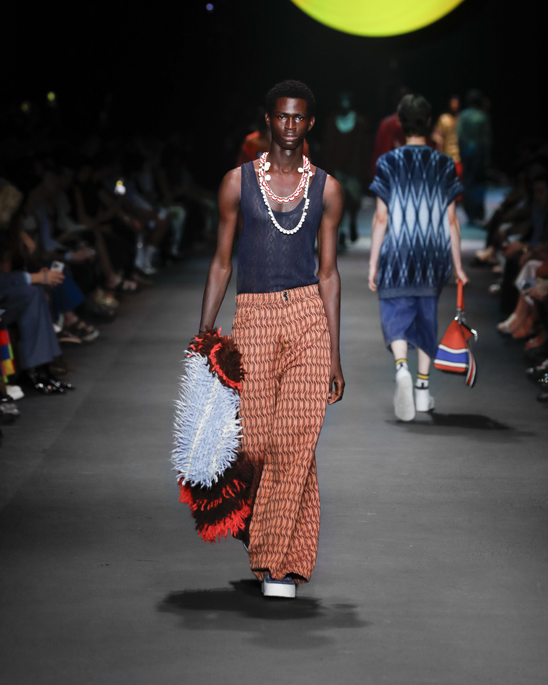 Model with two necklaces, transparent blue tank top, orange long trousers and multicoloured poncho Etro Spring Summer collection 2024 fashion show