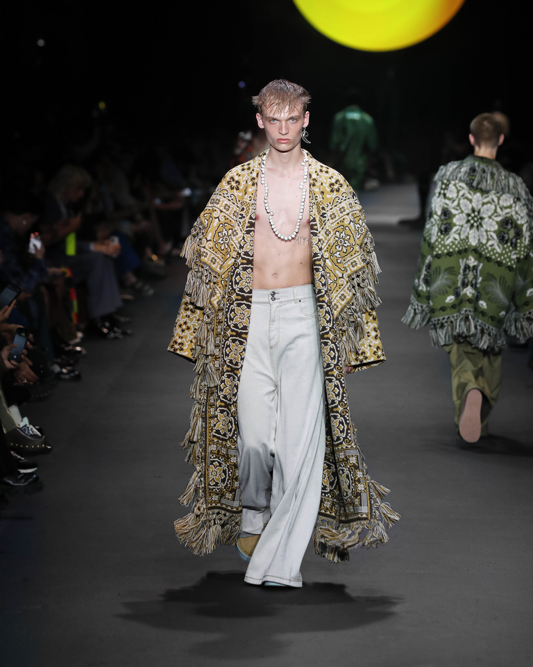 Model with white necklace, yellow poncho and white long trousers - Etro Spring Summer collection 2024 fashion show